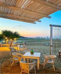 um pátio com mesas e cadeiras na praia em Hotel Gargano em Vieste