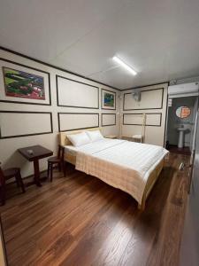 a bedroom with a bed and a table in it at Motel Ngọc Hiền in Pleiku
