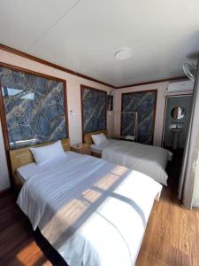 1 dormitorio con 2 camas en un barco en Motel Ngọc Hiền, en Pleiku