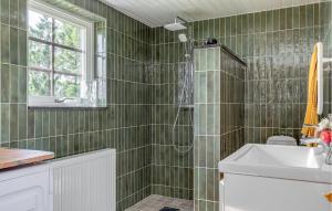 een groene betegelde badkamer met een douche en een wastafel bij Cozy Home In Lund With Kitchen in Lund