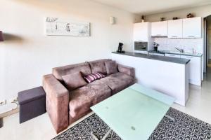 a living room with a couch and a table at Résidence Les Balcons de Collioure - maeva Home - Appartement 2 Pièces 4 Personnes Prestige - Vue mer MAE-3596 in Collioure