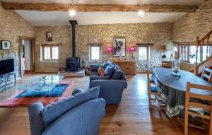 a living room with blue couches and a fireplace at Beautiful Home In Armillac With House A Panoramic View in Armillac