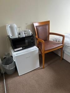 a room with a chair and a microwave next to a bed at 30 College Street, Buckhaven, Leven, Fife, KY81JX in Buckhaven