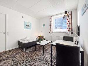 um quarto com uma cama, uma secretária e uma mesa em Nordbo in Centrum em Nuuk