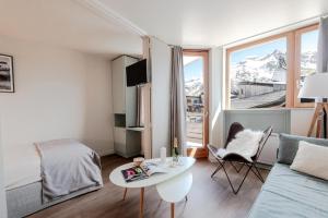 sala de estar con cama, mesa y ventana en Résidence Les Fontaines Blanches - maeva Home - 2 Pièces 4 Personnes Sélec 34 en Morzine