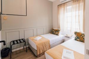 a small room with two beds and a window at Dear Faro - Guest House in Faro
