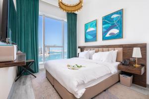 a bedroom with a large bed and a large window at 2BR Avani Palm View - CityApartmentStay in Dubai