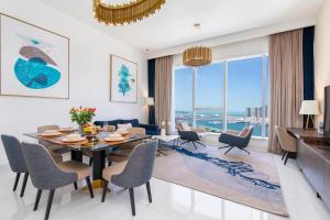 a dining room and living room with a table and chairs at 2BR Avani Palm View - CityApartmentStay in Dubai