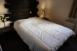 uma cama branca num quarto com 2 candeeiros em Résidence Les Fermes De Saint Gervais - 3 Pièces pour 6 Personnes 20 em Saint-Gervais-les-Bains