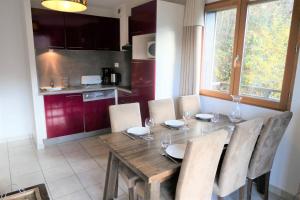 uma cozinha com uma mesa de madeira com cadeiras e uma sala de jantar em Résidence Les Fermes De Saint Gervais - 3 Pièces pour 6 Personnes 20 em Saint-Gervais-les-Bains