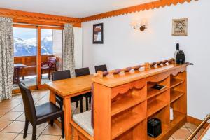 a dining room with a wooden table and chairs at Résidence Les Hauts Bois - maeva Home - Appartement 4 Pièces 8 Personnes - 82 in Aime-La Plagne