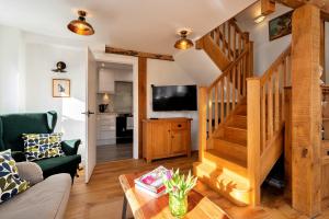 sala de estar con escalera y TV en Finest Retreats - Chilton Cottage, en Hungerford