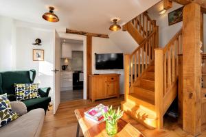 a living room with a staircase and a television at Finest Retreats - Chilton Cottage in Hungerford