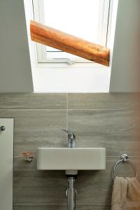 lavabo blanco en un baño con ventana en Finest Retreats - Chilton Cottage, en Hungerford