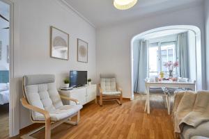 a living room with a table and chairs and a television at BBarcelona Central Eixample Flat in Barcelona