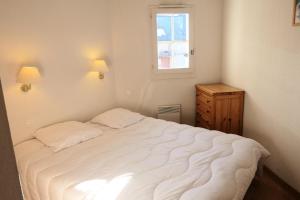 ein Schlafzimmer mit einem großen weißen Bett und einem Fenster in der Unterkunft Résidence Le Grand Panorama - 2 Pièces pour 6 Personnes 52 in Saint-Gervais-les-Bains