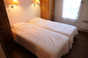 uma cama branca num quarto com uma janela em Résidence Le Grand Panorama - 3 Pièces pour 6 Personnes 56 em Saint-Gervais-les-Bains