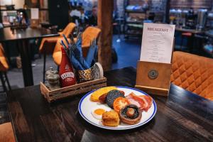 a plate of breakfast food on a wooden table at The Bull and Townhouse, Beaumaris- The Inn Collection Group in Beaumaris +83 photos