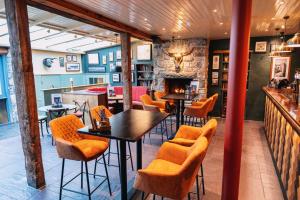 a restaurant with tables and chairs and a fireplace at The Bull and Townhouse, Beaumaris- The Inn Collection Group in Beaumaris