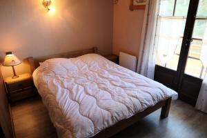 ein Schlafzimmer mit einem Bett, einem Fenster und einer Lampe in der Unterkunft Résidence La Gelinotte - 3 Pièces pour 6 Personnes 60 in Saint-Gervais-les-Bains