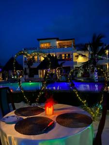 a table with plates of food and lights on a beach at Haber Hotel & SPA in Matemwe