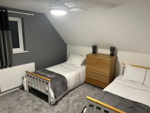 a bedroom with two twin beds and a dresser at Maple House a spacious 2 Bedroom House in Barnstaple