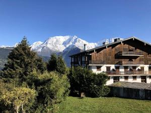 a building with a snow covered mountain in the background at Résidence La Gelinotte - 3 Pièces pour 6 Personnes 60 in Saint-Gervais-les-Bains