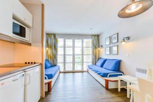 ein Wohnzimmer mit blauen Sofas und eine Küche in der Unterkunft Le Cap Glénan - maeva Home - 2 Pièces 5 Personnes Confort MAE-5640 in Bénodet