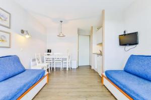 Zimmer mit 2 blauen Betten und einem Tisch in der Unterkunft Le Cap Glénan - maeva Home - 2 Pièces 5 Personnes Confort MAE-5640 in Bénodet