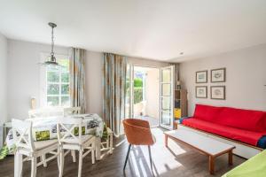 a living room with a red couch and a table at Le Cap Glénan - maeva Home - 2 Pièces 5 Personnes Confort MAE-5645 in Bénodet