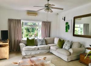 ein Wohnzimmer mit einem weißen Sofa und einem Spiegel in der Unterkunft Sagelands for business travel & family getaways in Durban