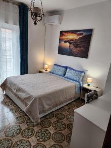 a bedroom with a bed and a painting on the wall at Аppartamenti vicino al mare in Scalea