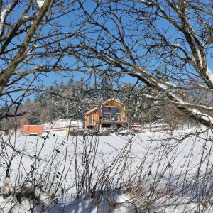 a house in a snow covered field with trees at Dream Catcher House 