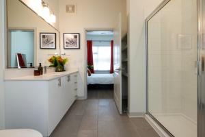 a bathroom with a shower and a sink and a mirror at TWO Stunning Nulu CozySuites in Louisville