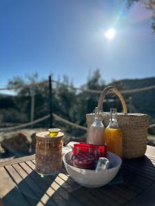 a picnic table with a bowl of food and a basket at SUITE 19 BUBBLE BY CORTIJO COLOMO in Almedinilla