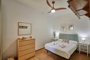 - une chambre avec un lit et un ventilateur de plafond dans l'établissement BBarcelona Central Eixample Flat, à Barcelone