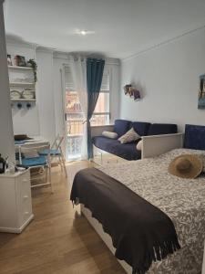 a bedroom with a bed and a living room at Estudios Muñoz in Alicante