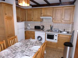 a kitchen with a table with chairs and a sink at Résidence Schuss - 3 Pièces pour 8 Personnes 35 in Les Contamines-Montjoie