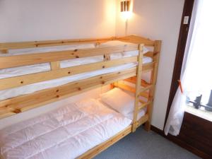 a bunk bed in a room with a wooden bunk bed at Résidence Schuss - 3 Pièces pour 8 Personnes 35 in Les Contamines-Montjoie