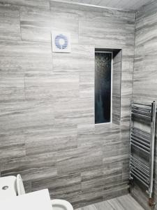 a bathroom with a toilet and a stone wall at Perry House in Nottingham