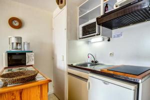a small kitchen with a sink and a microwave at Résidence Mané Vihan proche de la plage - maeva Home - Appartement 2 Pièces 4 Personnes Budget MAE-7335 in Arzon