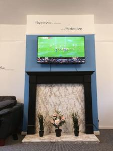 ノッティンガムにあるPerry Houseの暖炉の上のテレビ