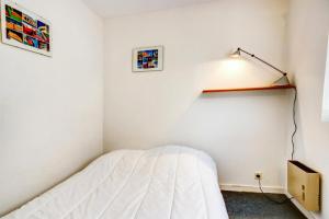 a bedroom with a bed and a light on the wall at Résidence Mané Vihan proche de la plage - maeva Home - Appartement 2 Pièces 4 Personnes Budget MAE-7335 in Arzon