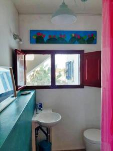 baño con lavabo y ventana en Al Gelso Bianco appartamento, en Castrignano del Capo