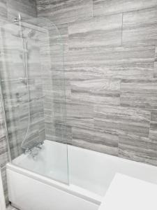 a bathroom with a shower and a white bath tub at Perry House in Nottingham
