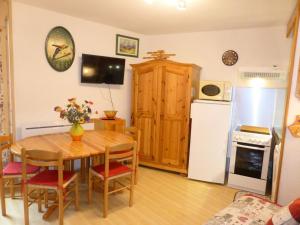a kitchen and dining room with a table and a refrigerator at Résidence Pierres Blanches - Studio pour 6 Personnes 42 in Les Contamines-Montjoie
