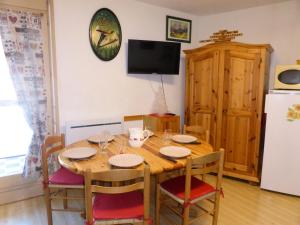 mesa de comedor con sillas y nevera en Résidence Pierres Blanches - Studio pour 6 Personnes 42, en Les Contamines-Montjoie