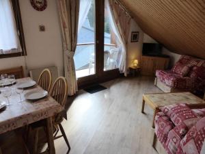 sala de estar con mesa y sofá en Résidence Combettes - 2 Pièces pour 5 Personnes 52, en Les Contamines-Montjoie