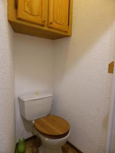 a bathroom with a white toilet with a wooden lid at Résidence Combettes - 2 Pièces pour 5 Personnes 52 in Les Contamines-Montjoie