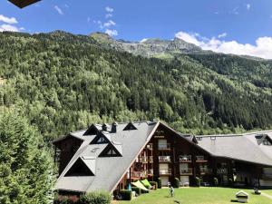 a large building with a mountain in the background at Résidence L'enclave - Studio pour 4 Personnes 54 in Les Contamines-Montjoie
